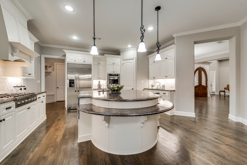    Gourmet Kitchen with Large Island  Granite Counters and Sleek Glass Tile Backsplash 