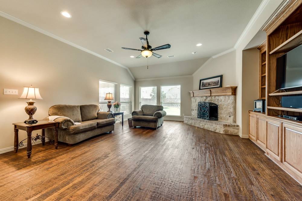    Inviting Family Room features Wall of Built In Cabinetry and Stone Fireplace 