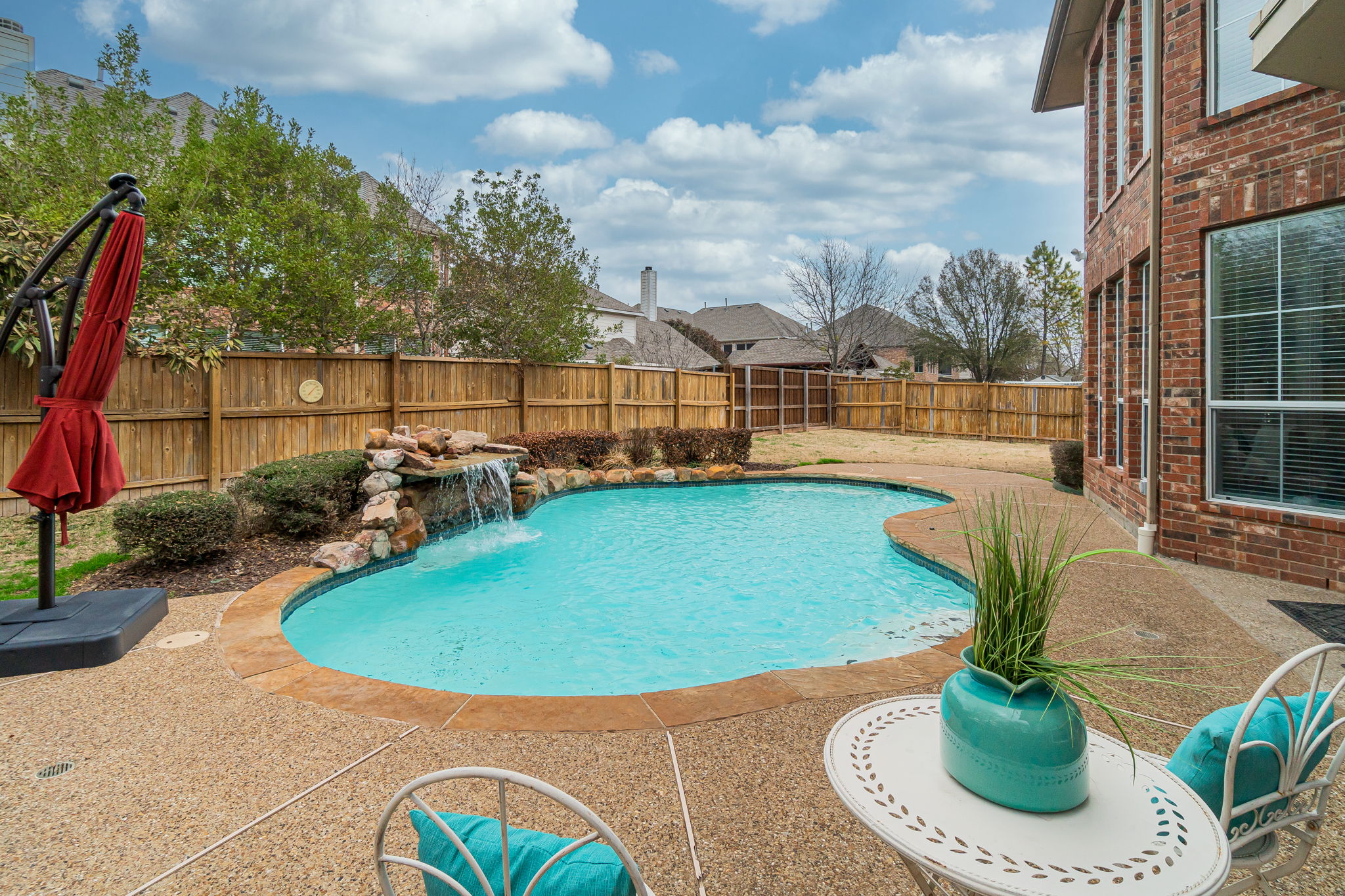    Serene Backyard with Sparkling Swimming Pool and Grassy Play Area 