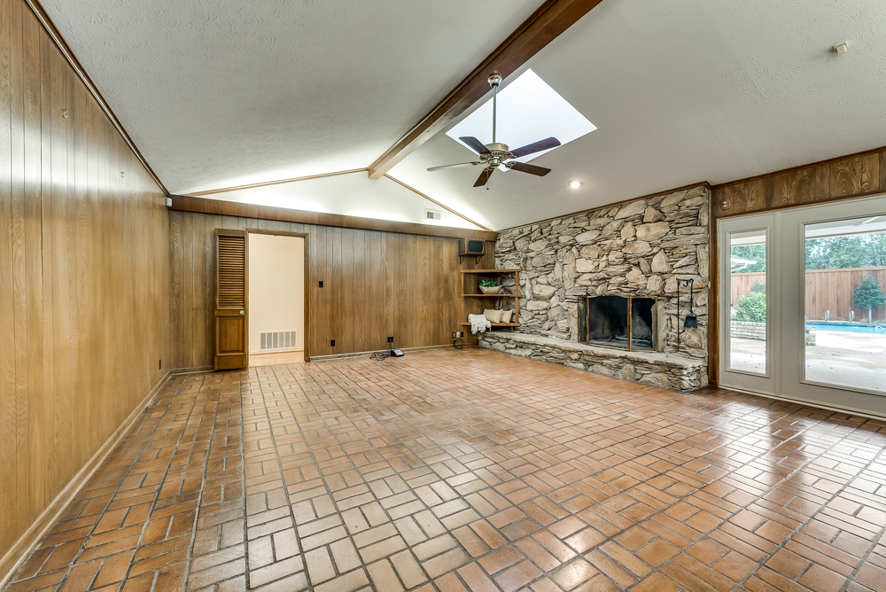    Large Family Room with Stone Fireplace  Beamed Ceiling and Wood Paneling and Wall of Built Ins 