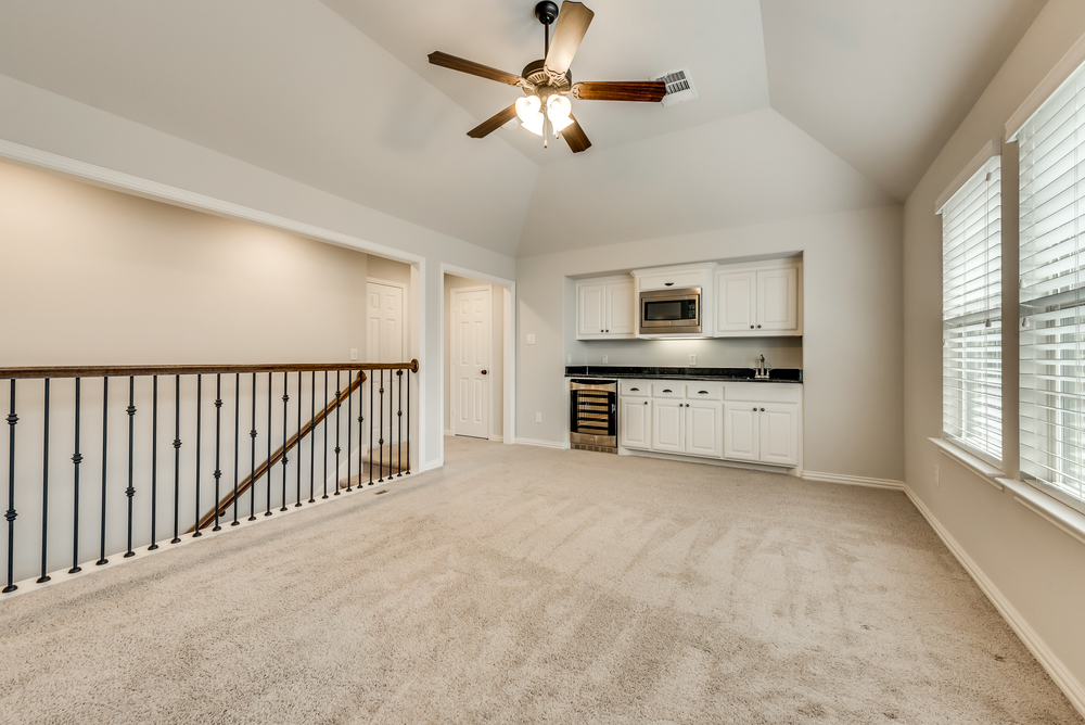    Upstairs Game Room with Wet Bar featuring Granite Countertops Wine Fridge Sink and Built In Microwave 